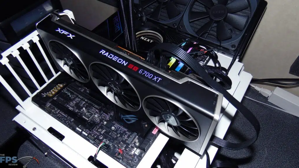 XFX SPEEDSTER MERC 319 BLACK AMD Radeon RX 6700 XT installed in motherboard on testing bench top view rgb lighting